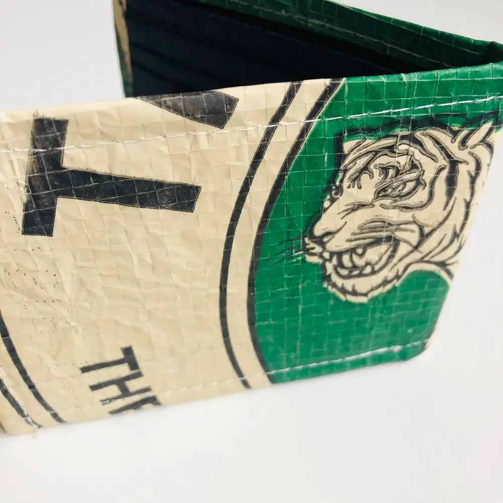 Close-up of a green and beige wallet with a tiger design on a white background