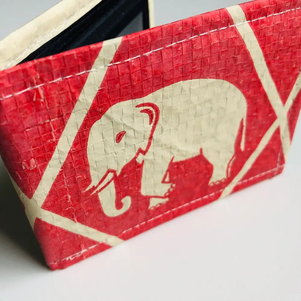 Red wallet with a beige elephant design on a white background