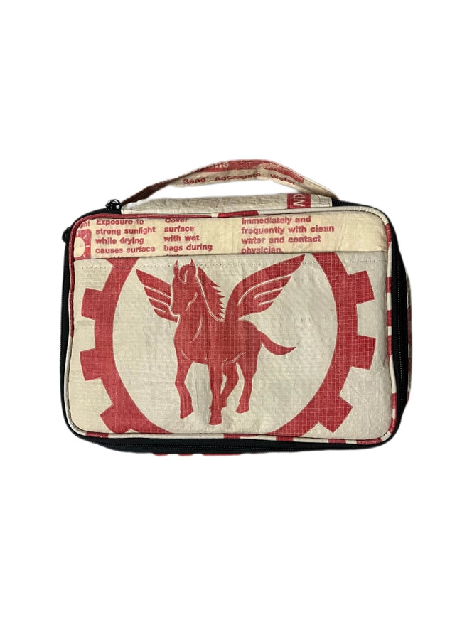 The Cement6 Lunch Box is a rectangular, artisan-made insulated bag with a handle, crafted from repurposed materials. It features a red Pegasus logo inside a gear and red typewriter-style text printed on top.