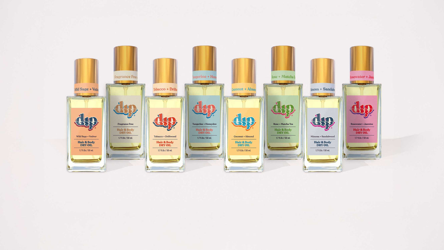 dip hair and body dry oil in a clear bottle with gold lid line up of all scents