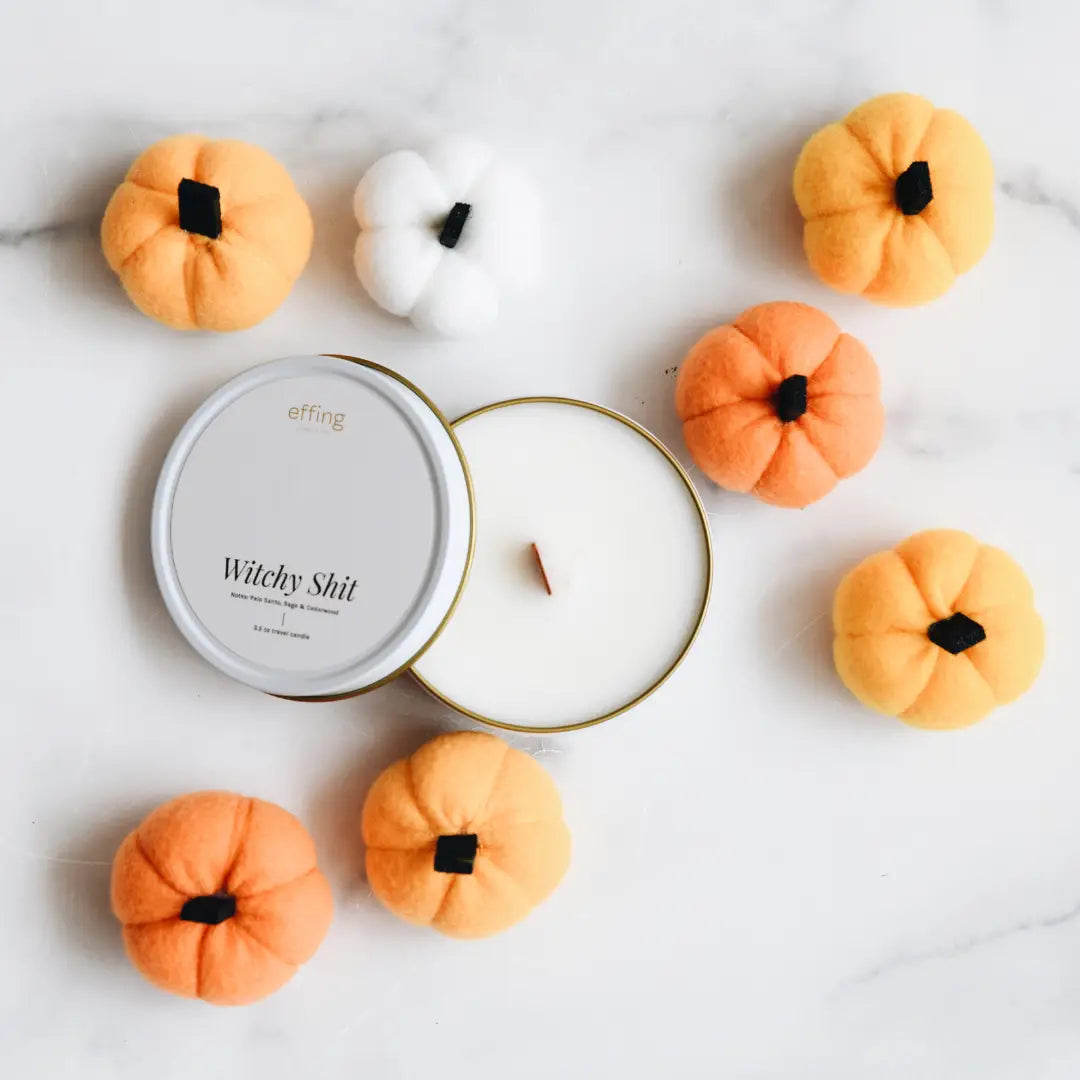 Candle with decorative pumpkins on a light background