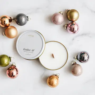 Decorative candles with Christmas ornaments on a marble surface