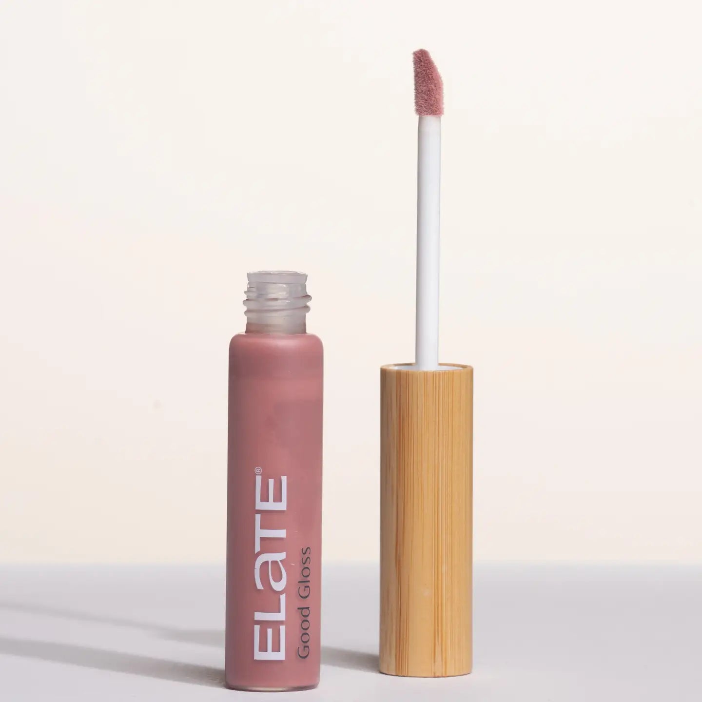 Elate lip gloss with pink applicator on a light background