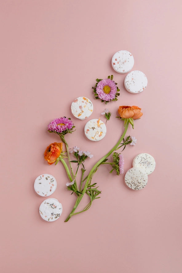 pink background with flowers and shower steamers scattered