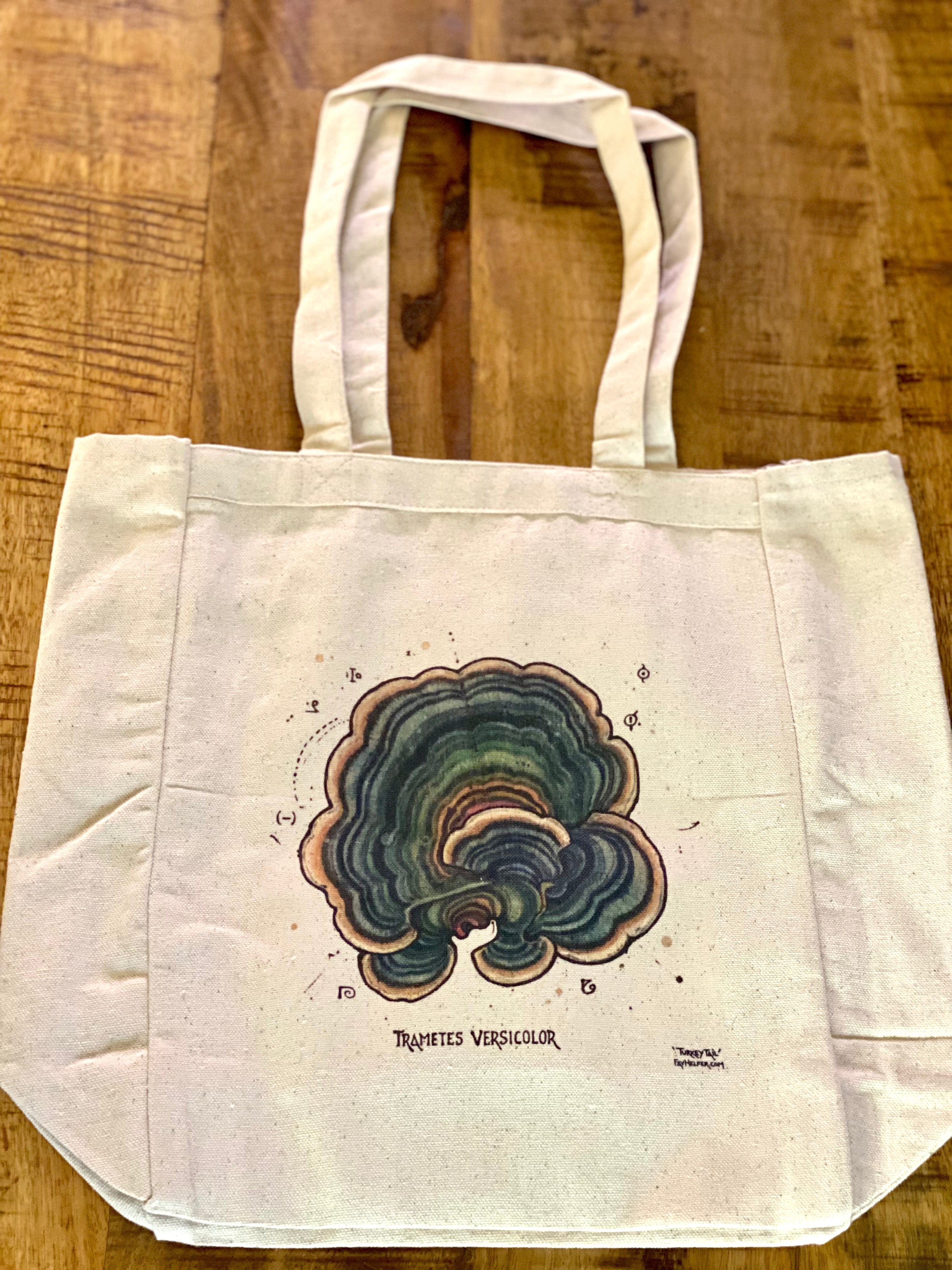 The Mushroom Tote Bag by Fay Helfer is a cream eco cotton bag featuring a multicolored turkey tail mushroom (Trametes versicolor) illustration with its name below, designed as a unique medicinal mushrooms tote.