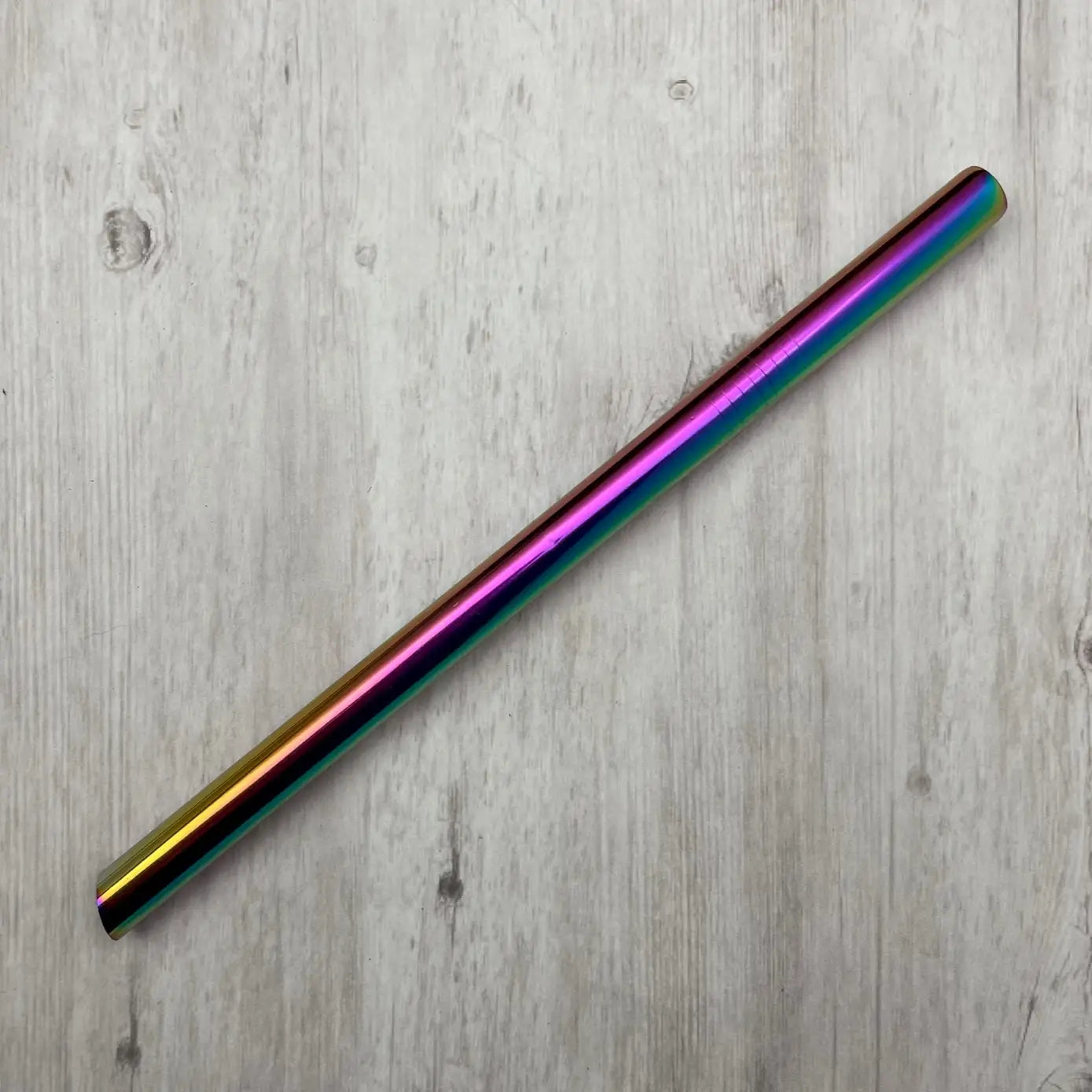 Multicolored metallic boba straw on a wooden surface