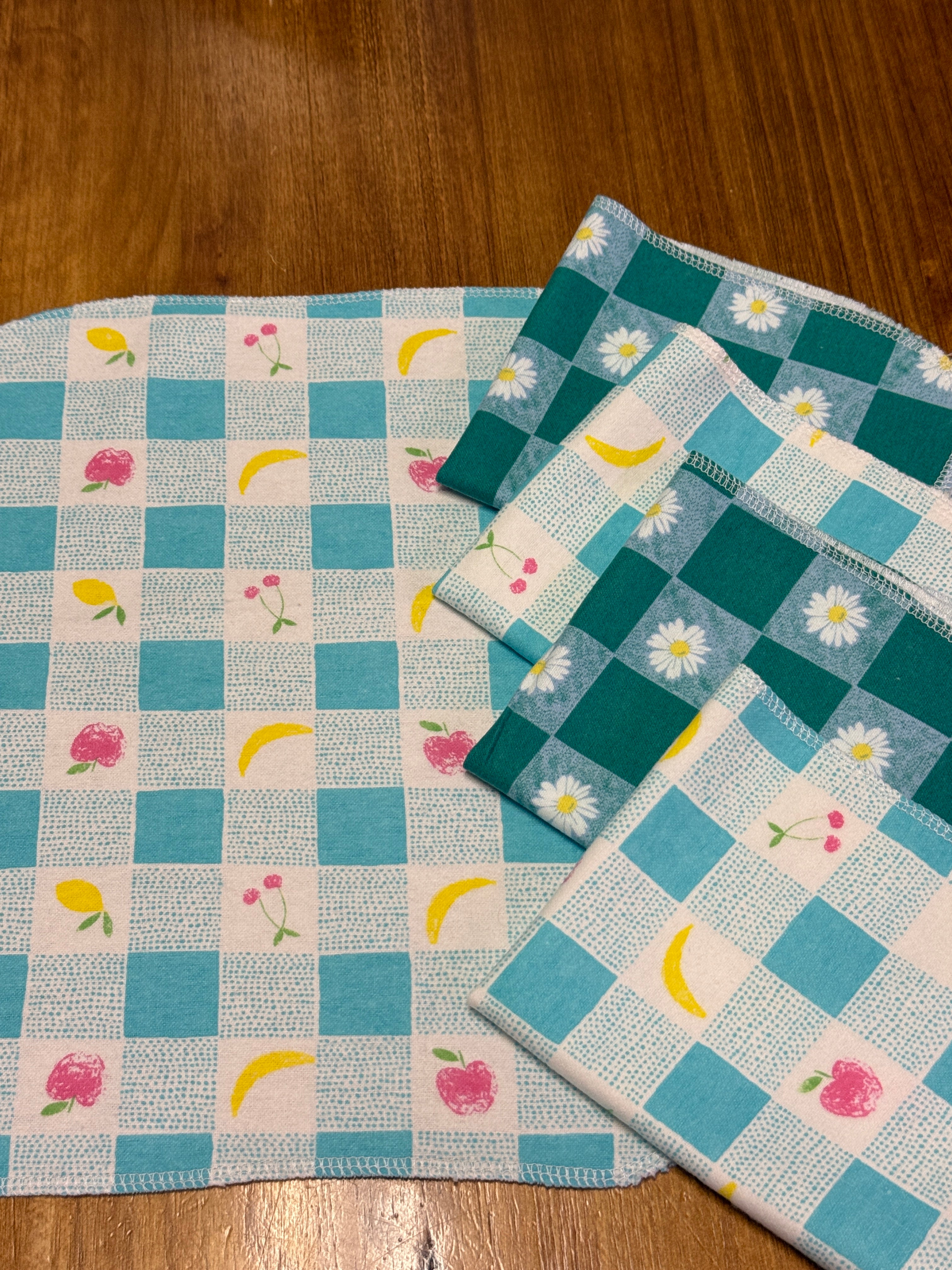 not paper towels lined up, blue checkers with fruit and green checkers with daisies