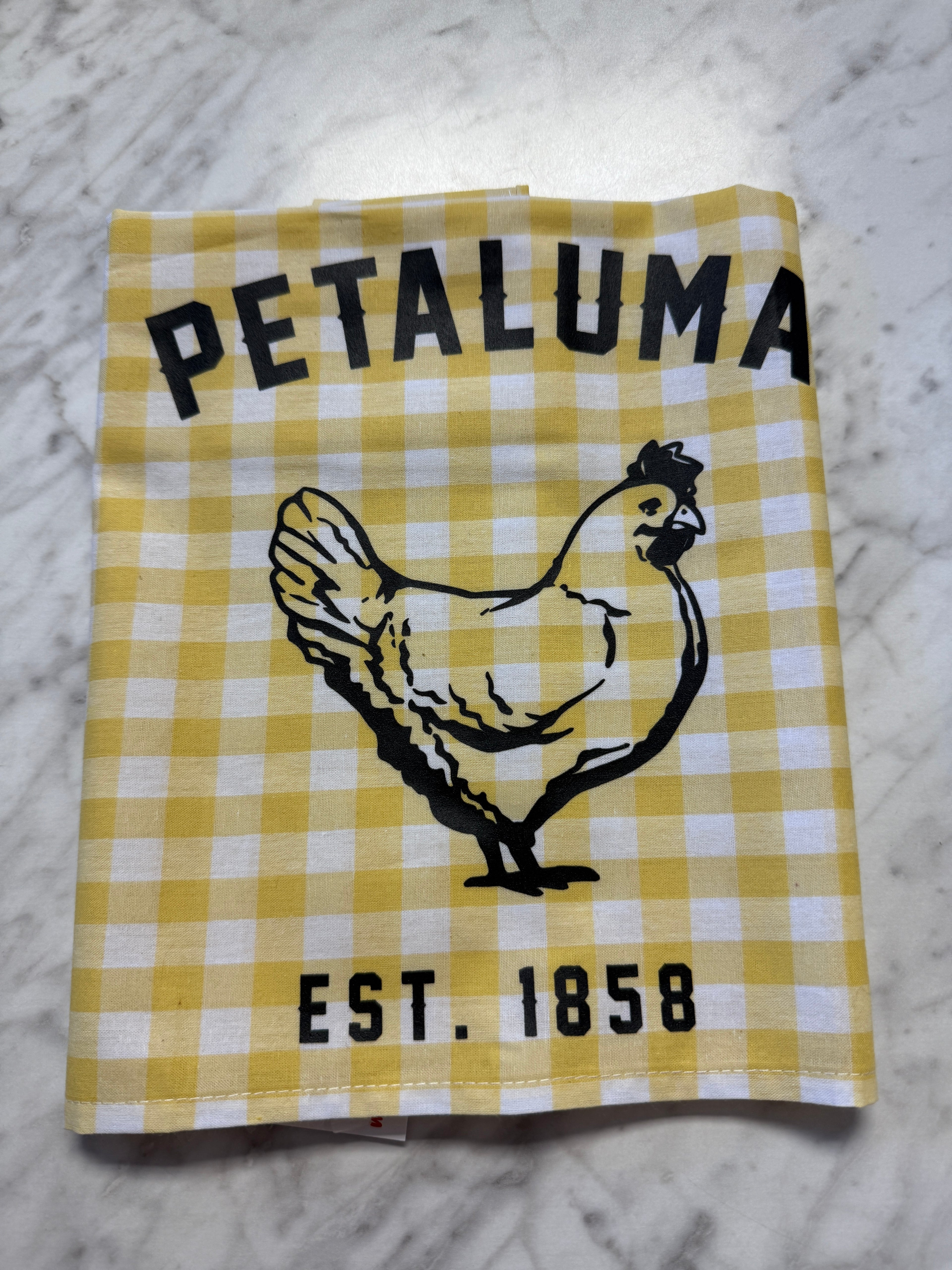 Yellow and white checkered towel with a chicken illustration and &