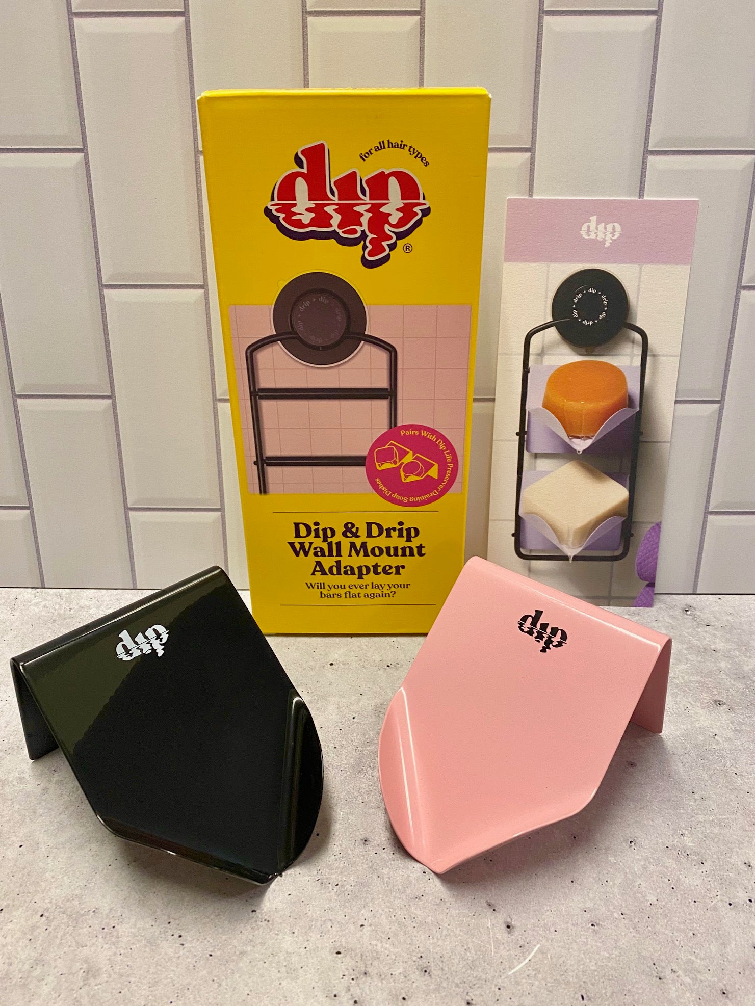 dip slanted soap dishes in black and pink with the wall mount adapter behind