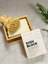 bamboo dish brush on top of bamboo soap holder with white soap and white box of a dish block on top