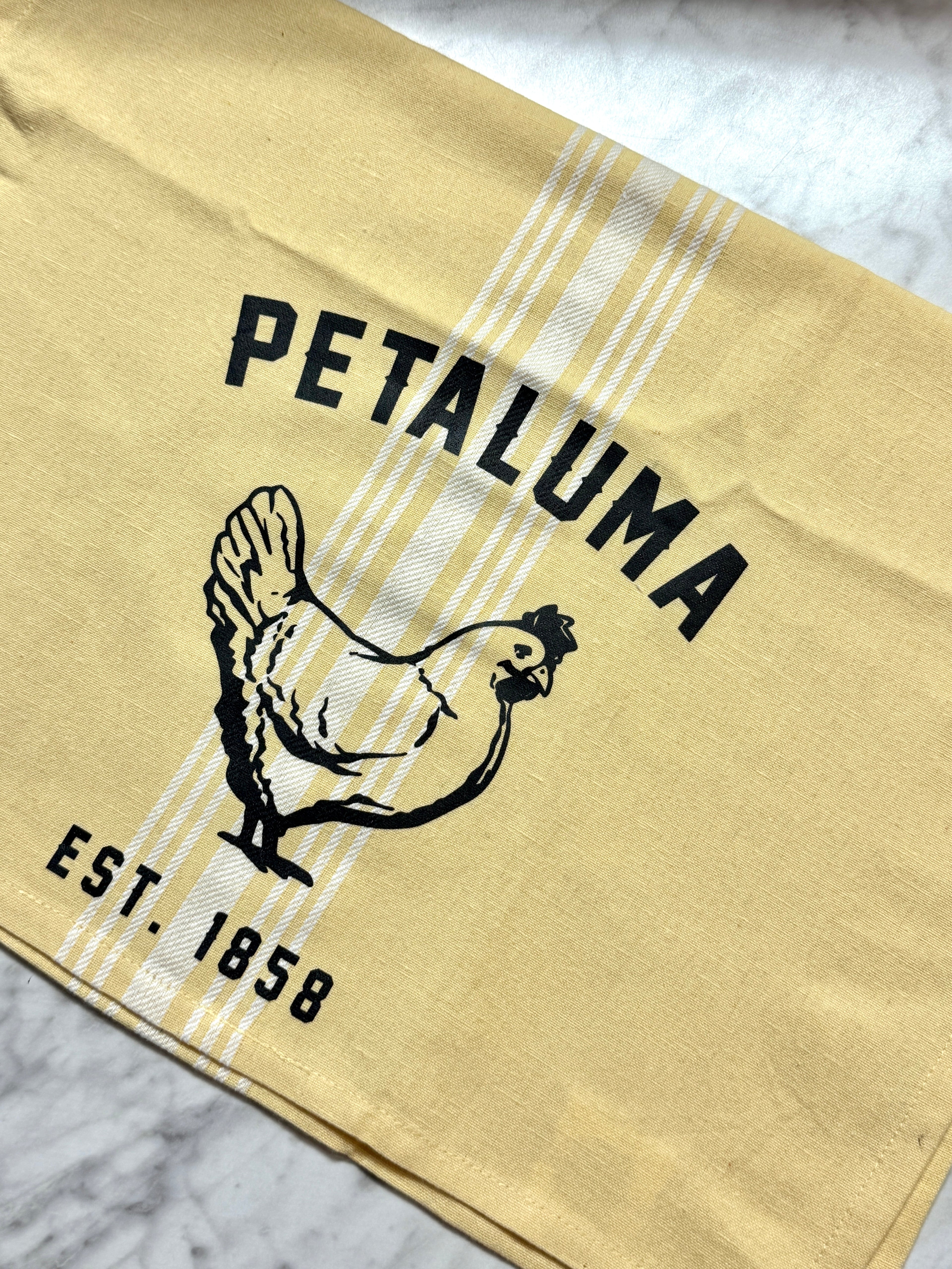 Beige towel with black rooster illustration and &