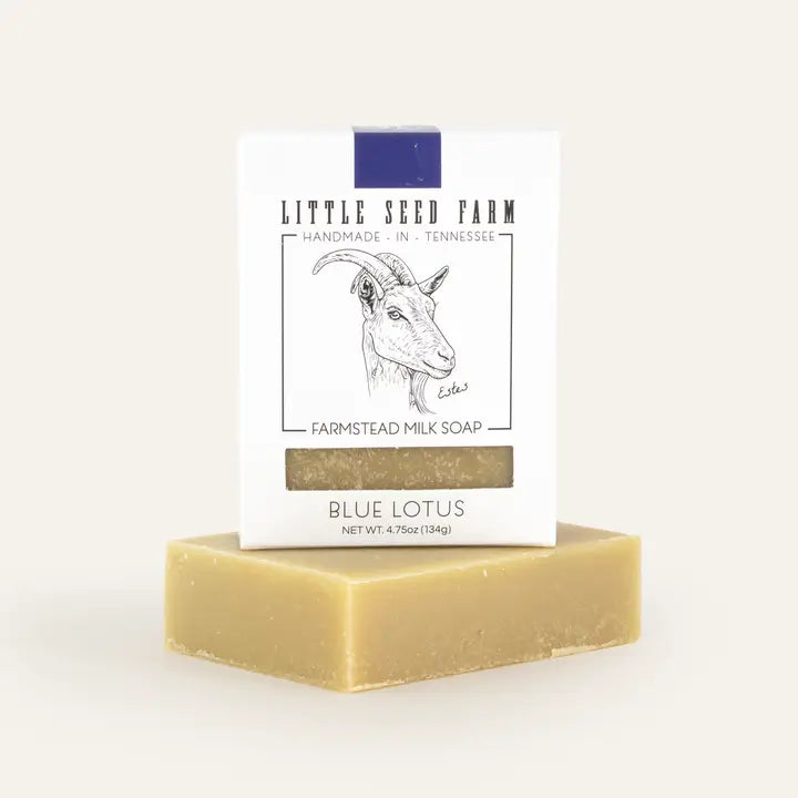 blue lotus soap in white box on top of bar of goat milk soap