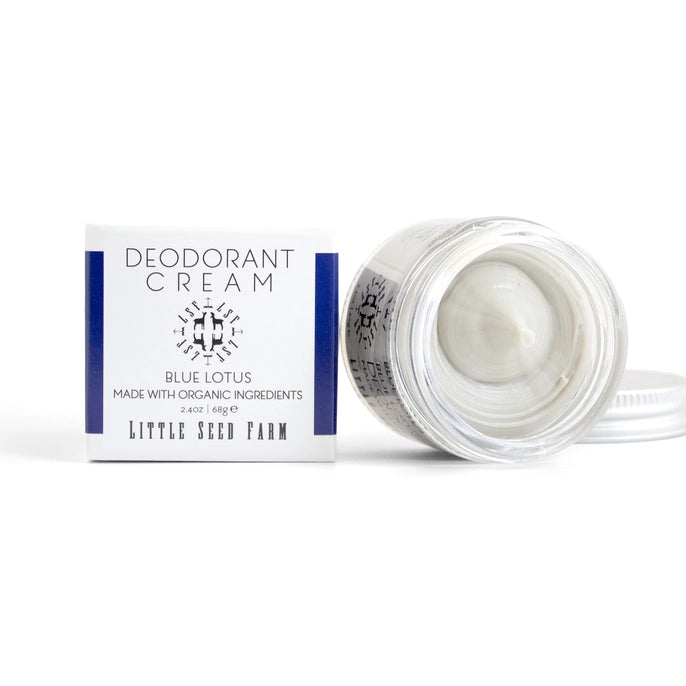 An open jar of Little Seed Farm Deodorant Cream sits next to its white box with blue accents and product details, revealing the aluminum-free cream inside.