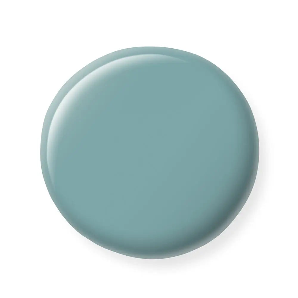 Round teal nail polish sample on a white background