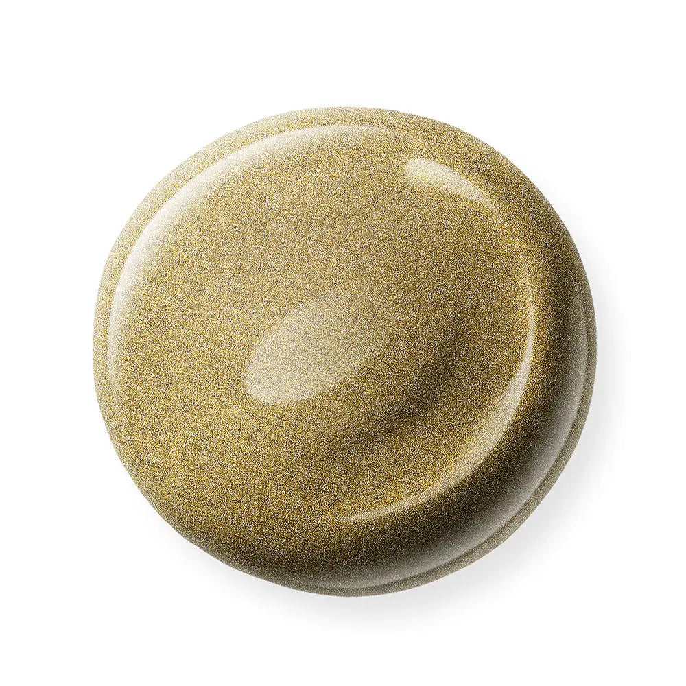 Round, gold nail polish sample on a white background