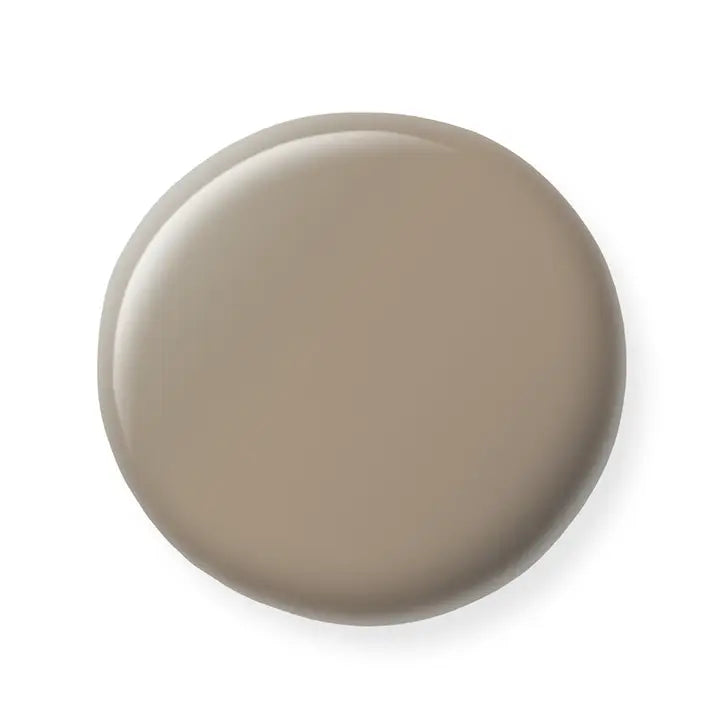 Round beige nail polish sample on a white background