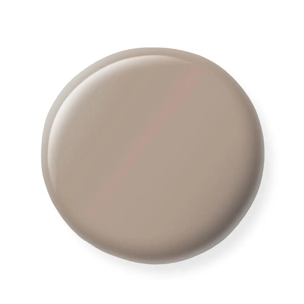 Round beige nail polish sample on a white background