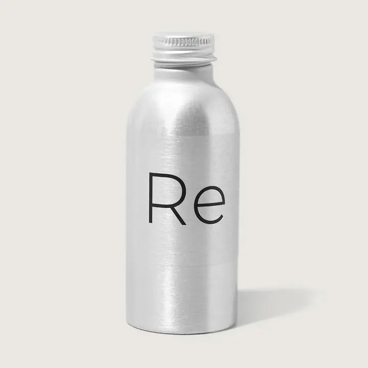 A compact silver metallic bottle with a screw cap, featuring "Re" in black on the front, holds Rebrand’s Foresight Sunscreen SPF 30—mineral sunscreen for face—shown against a plain light background.