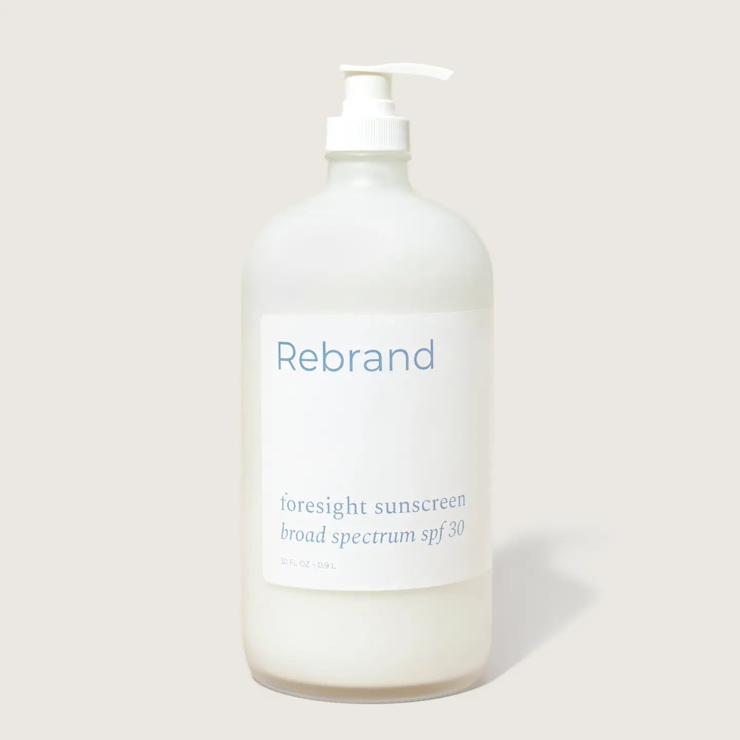 A clear pump bottle labeled Rebrand holds Bulk Face Sunscreen SPF 30, a refillable mineral sunscreen with zinc oxide and broad spectrum protection, shown against a plain light background.