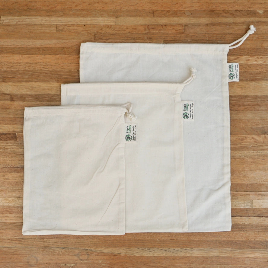 3 different sized muslin produce bags with a string tie