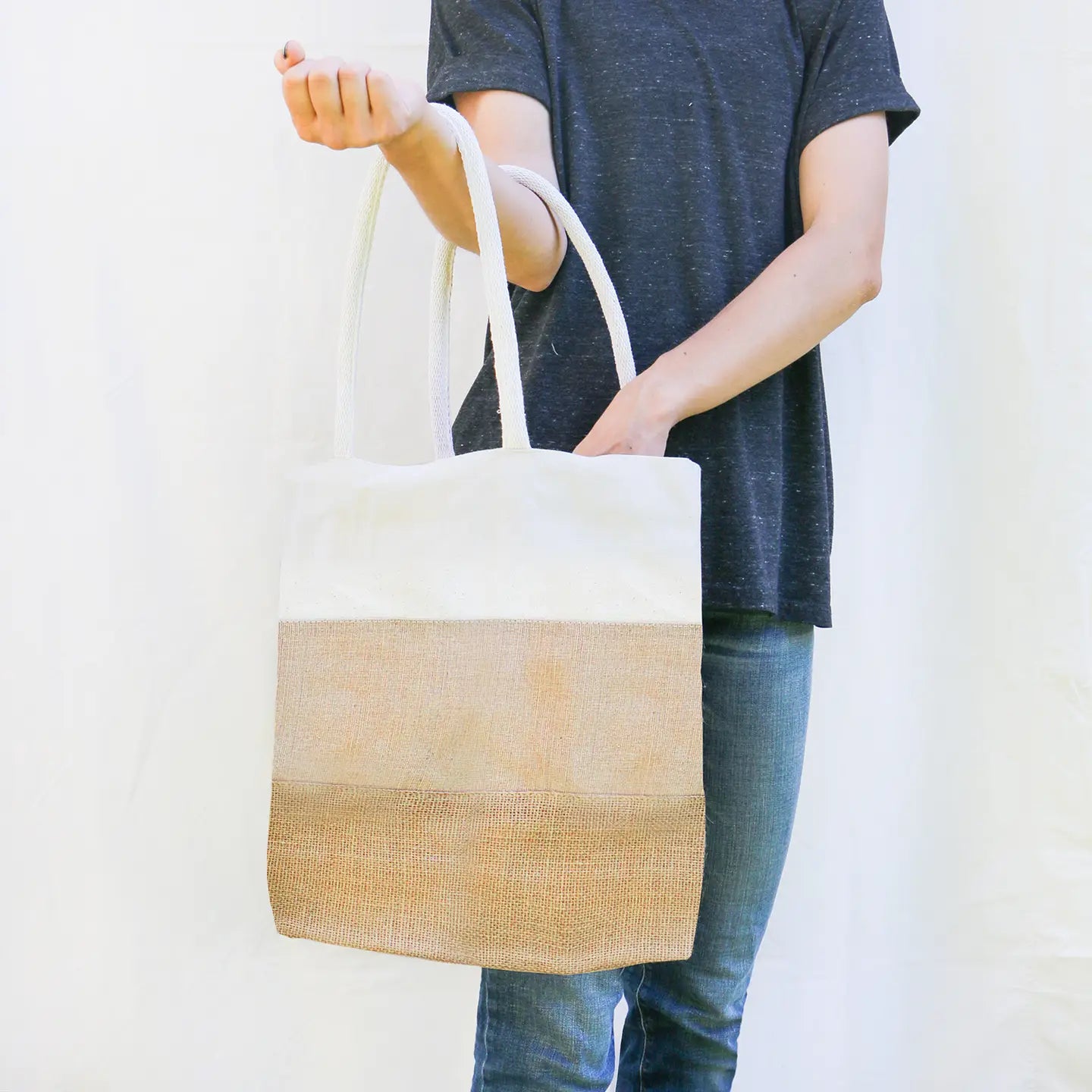 person holding tri color tote bag