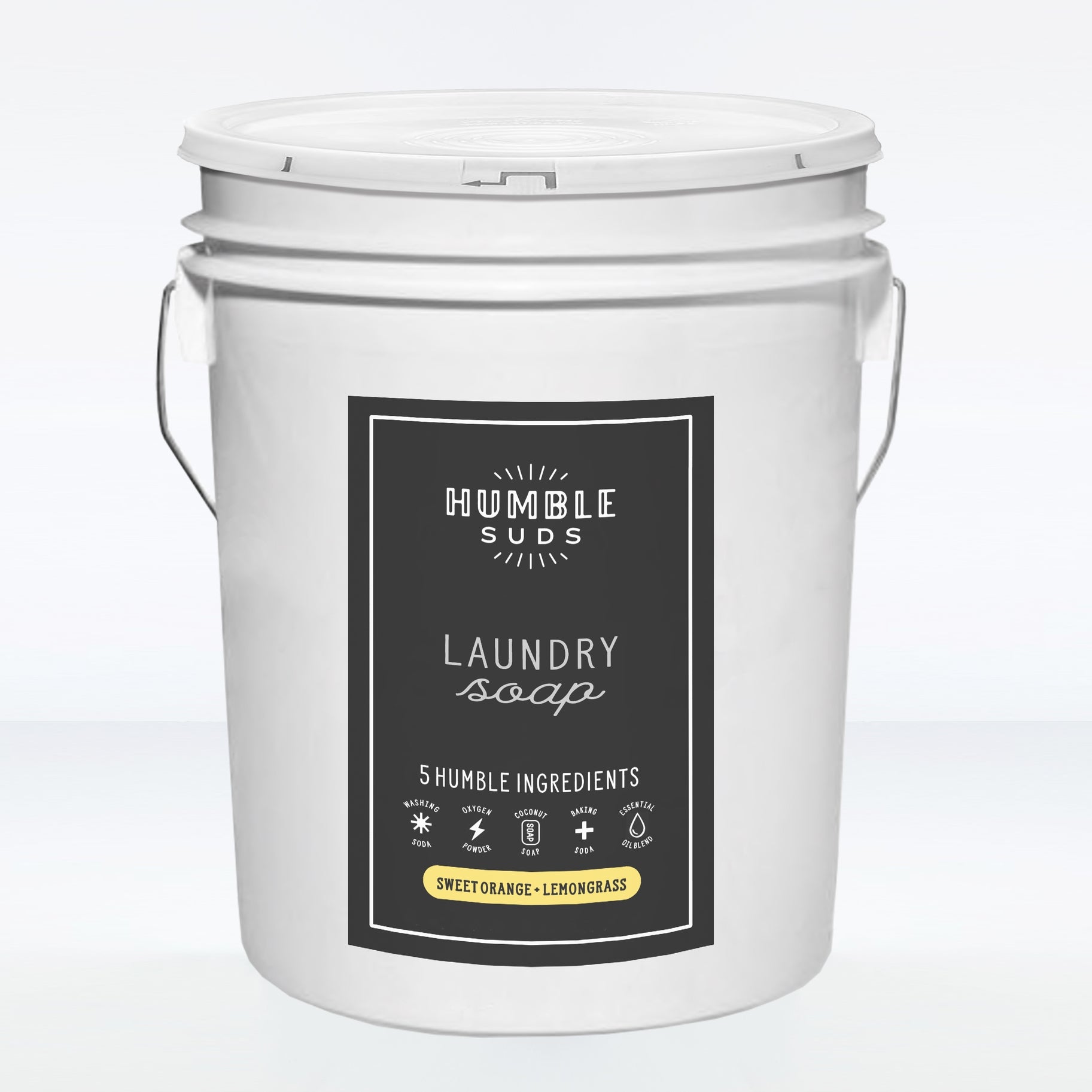 A white bucket of Humble Suds Bulk Laundry Soap, featuring a black label with five simple ingredients and Sweet Orange + Lemongrass scent. Non-toxic and safe for sensitive skin, the bucket has metal handles on both sides.