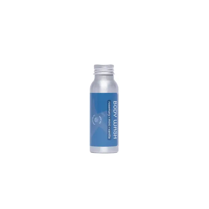 A small, refillable aluminum bottle from Plaine Products with a blue label reading "Body Wash" in white text. The minimalist design features a screw cap and is shown against a plain white background.