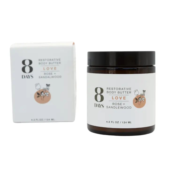 A jar of 8 Days Botanicals Body Butter - Rose Sandalwood sits beside its box, both with white labels featuring black, gold, and pink text, a rose illustration, and details about nourishing organic butters.