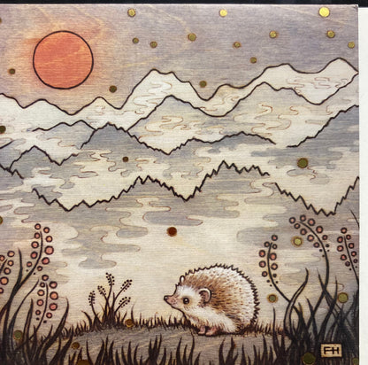 A small hedgehog stands in grassy plants, facing distant mountains under a reddish sun in a cloudy sky. This whimsical scene, with soft colors and gold accents, inspires the Artist Fay Helfer Greeting Cards from Fay Helfer.