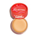 A round tin of Axiology Fungdation Mushroom Foundation with a red lid, brand name, and colorful wavy pattern is shown open to display the light beige foundation inside.