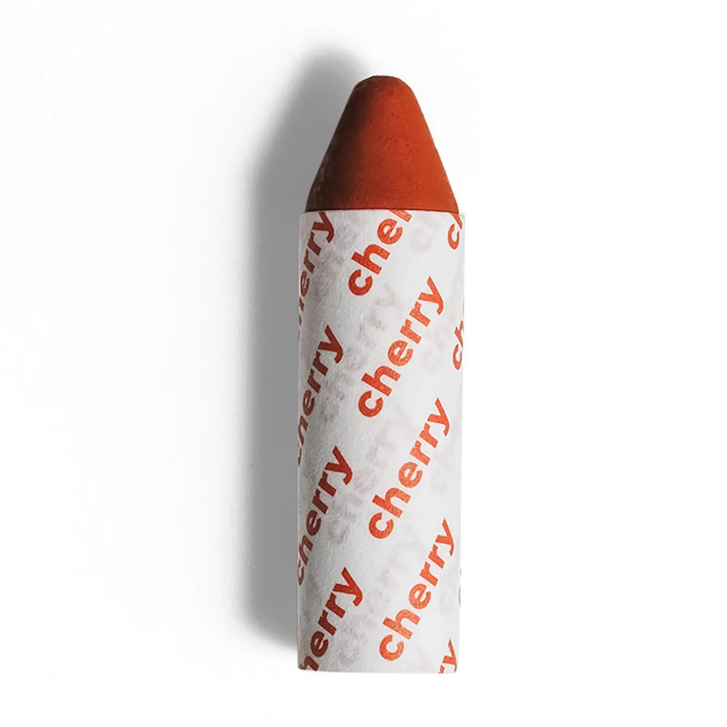Axiology 3-in-1 Balmie Crayon Single in cylindrical red, with a pointed tip and white paper wrap printed “cherry” in red. This plastic-free multi-use makeup crayon is shown against a plain white background. 