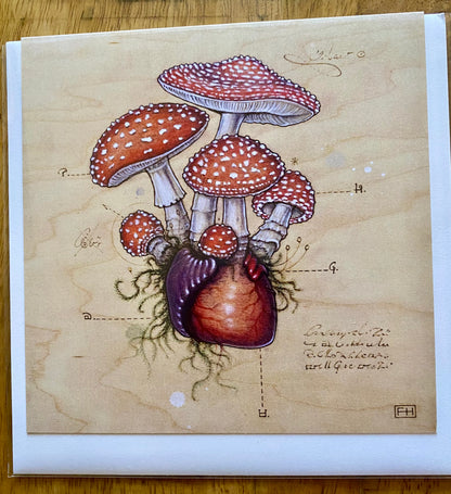 Inspired by Fay Helfer, this Artist Fay Helfer Greeting Card features red mushrooms with white spots emerging from a realistic heart, set on a tan background with vintage-style handwritten notes and diagrams.