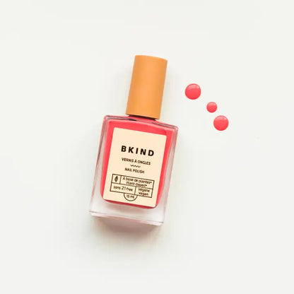 A bottle of BKind Nail Polish by BKind, featuring a beige cap and filled with bright pink polish, is displayed on a white background with three drops of pink nail polish beside it.