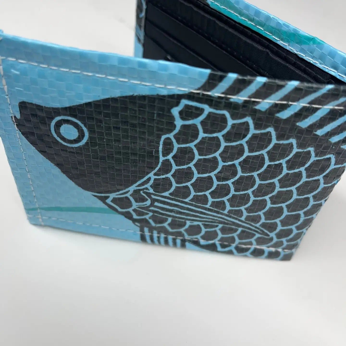 Blue and black fish-patterned wallet on a white background