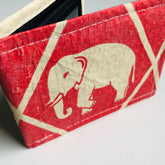 Red wallet with a beige elephant design on a white background