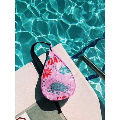 Pink bag with fish design on a poolside background
