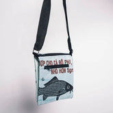 Crossbody bag with fish design and text on a light gray background