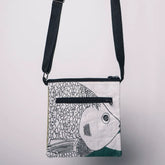 Crossbody bag with fish design on a light gray background