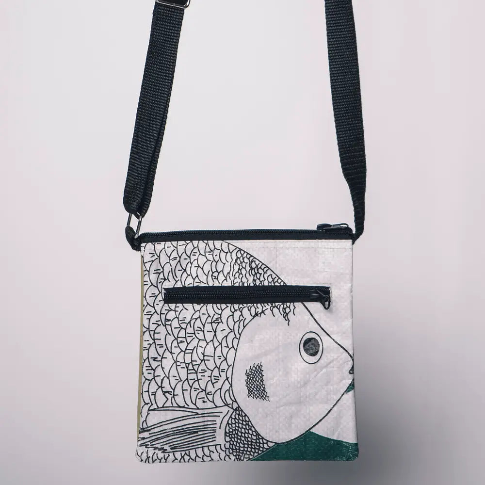 Crossbody bag with fish design on a light gray background