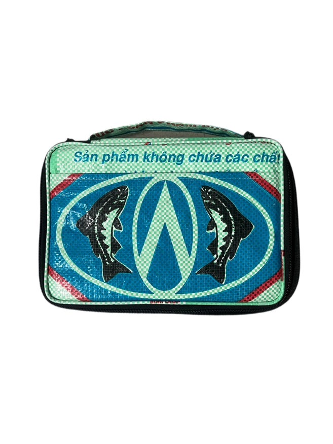 The Cement6 Lunch Box is a rectangular, green and blue insulated bag with black trim, showcasing two fish illustrations and Vietnamese text “Sản phẩm không chứa các chất”—sustainable, stylish, and practical for everyday use.