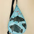 Light blue sling bag with fish design on a beige background
