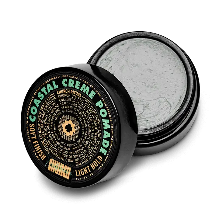 An open black container of Curch California Cream Pomade - Light Hold reveals light gray cream inside. The label features Soft Finish and Light Hold in green, gold, and white, centered by a cross logo.