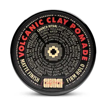 Round black container of Curch California Volcanic Clay Pomade - Firm Hold, with bold red and tan text. The matte lid highlights this natural hair pomade and features ritual instructions displayed in a circular pattern.