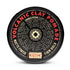 Round black container of Curch California Volcanic Clay Pomade - Firm Hold, with bold red and tan text. The matte lid highlights this natural hair pomade and features ritual instructions displayed in a circular pattern.