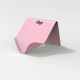 A pink, folded, tent-shaped Life Preserver Draining Soap Dish by Dip, featuring the brand&