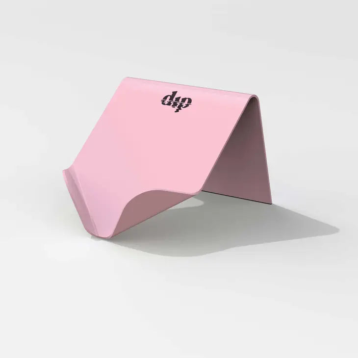 A pink, folded, tent-shaped Life Preserver Draining Soap Dish by Dip, featuring the brand&