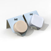Two Life Preserver Draining Soap Dishes from Dip, made of durable metal, sit on a white surface—one cradling a round beige soap, the other a square white bar. An eco-friendly solution for neat soap organization.