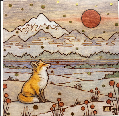 A fox sits on snowy ground with red plants, gazing at a red sun, mountains and swirling clouds behind. Gold dots evoke foil art prints. Featured on Artist Fay Helfer Greeting Cards by Fay Helfer.
