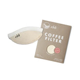 The Ebb Handheld Brewer by GDS Cloth Goods, a reusable coffee filter with "ebb" printed on its side, is pictured with its brown cardboard packaging labeled ebb and COFFEE FILTER on a white background.