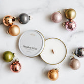 Decorative Christmas ornaments and candles on a marble surface